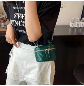 Detailansicht der dunkelgrünen gesteppten Vanity Bag mit goldener Kette am Model
