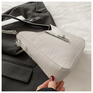 Detailed macro view of white crocodile pattern leather and silver metal twist lock