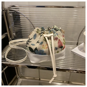 Close-up of ethnic floral jacquard pattern and leather drawstring on bucket bag