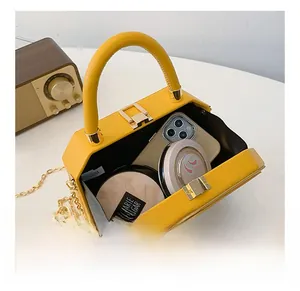 Interior view of yellow box handbag showing capacity for phone and cosmetics