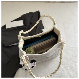 Macro view of large white bucket bag showing spacious interior with daily essentials