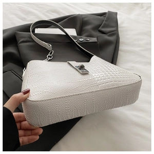 Detailed view of white crocodile pattern shoulder bag with silver metal rotary clasp
