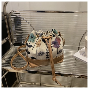 Close-up of floral jacquard weave pattern and drawstring closure on retro bucket bag