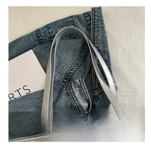 Detail shot of the silver metallic tote bag showing comfortable handle and pleated texture