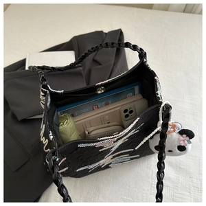 Top view of large black embroidered bucket bag showing spacious interior with daily items
