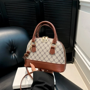 Vintage shell bag with monogram pattern and brown leather trim in a structured hand-held style