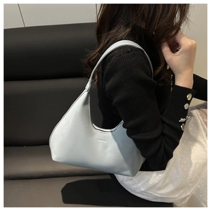 Close-up of a light blue faux leather crescent hobo bag with embossed FASHION logo detail