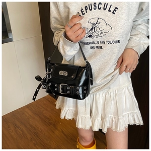 Détail du sac bandoulière en cuir verni noir avec fermoir tournant CD argenté et nœud