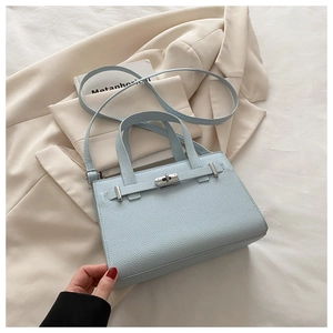 Close-up of light blue lychee pattern faux leather bag with silver metal swivel lock