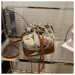 Close-up of ethnic style bucket bag with floral jacquard texture and leather drawstring