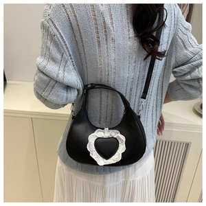 Detail of black semi-circle bag with lace heart patch and matte faux leather texture
