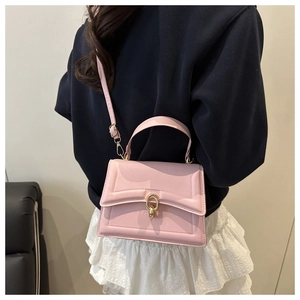 Detail showing pink structured crossbody bag with gold buckle on model back view