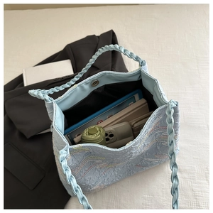 Spacious interior of light blue textured tote bag holding umbrella, phone and tablet