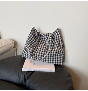 Detailed view of black and white checkered tote bag fabric and sturdy canvas handles