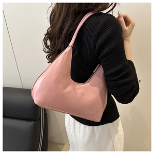 Detail shot of a pink crescent underarm bag worn by a model showing style and capacity