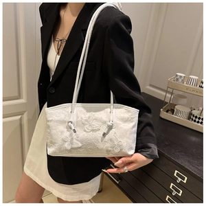 Detailed shot of white lace tote bag with 3D butterfly embroidery on model's shoulder