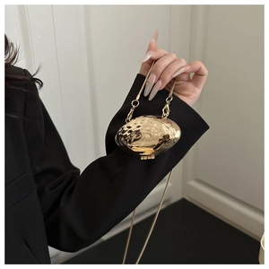 Vue détaillée d'une pochette dorée en forme d'olive avec texture martelée et bandoulière