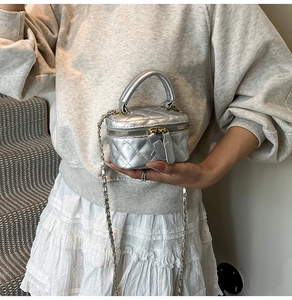 Close-up of silver quilted leather mini vanity bag with metal chain strap
