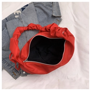 Detailed interior of red ruched nylon shoulder bag showing wide opening and silver zipper