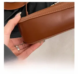 Macro detail of precision stitching on brown crocodile embossed leather crescent bag
