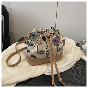 Detailed close-up of ethnic jacquard bucket bag with floral patterns and leather drawstrings