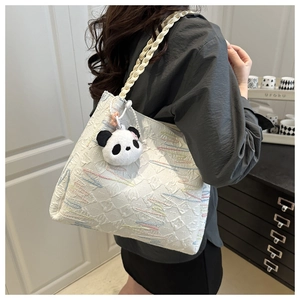Detail of white tote bag showing diamond texture embroidery and cute panda charm
