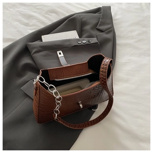 Internal view of dark brown croc-effect bag showing space for wallet and phone