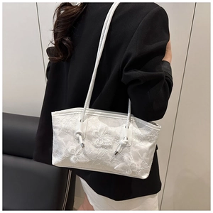 Detail of white lace tote bag featuring 3D floral butterflies and elegant shoulder straps