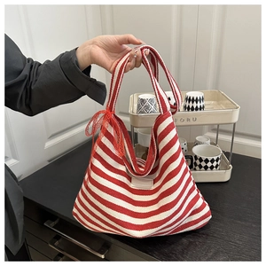 Détail d'un sac fourre-tout en toile à rayures rouges et blanches avec nœud en dentelle