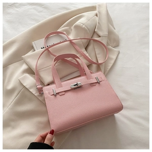 Detailed view of pink lychee texture leather handbag with silver clasp on office blazer