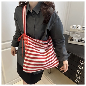 Détail du cabas en toile rayé rouge et blanc orné d'un nœud décoratif en dentelle rouge