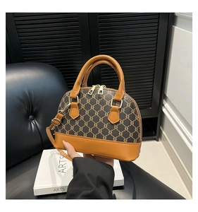 Retro monogram shell handbag in vintage brown leather featuring dual handles and crossbody strap