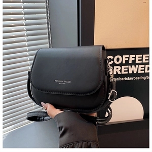 Fashionable black matte leather saddle bag with silver logo and adjustable strap