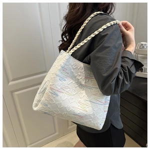 Detail of white tote bag featuring colorful wavy embroidery and thick woven rope handle