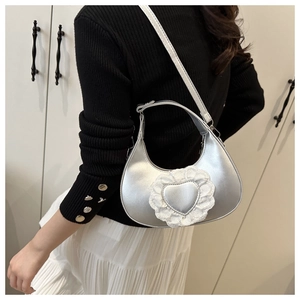 Silver metallic heart crescent bag with white lace detail shown on model side profile