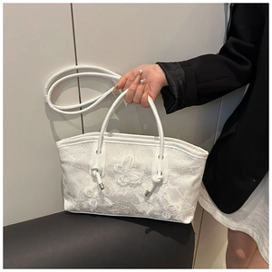 Close-up of white lace embroidery tote bag with 3D butterfly details and dual straps