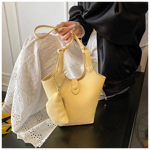 Close-up of the yellow lychee grain leather bucket bag with knotted handle detail