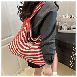 Detailed view of large capacity red and white striped tote bag with red lace shoulder strap
