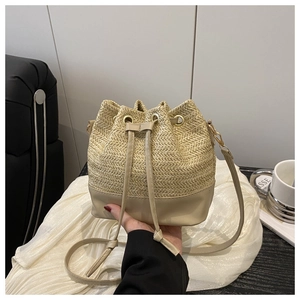 Detail of straw bucket bag with drawstring closure and adjustable leather strap