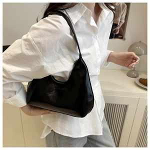 Close-up of black crescent hobo shoulder bag in soft leather on a model for daily use