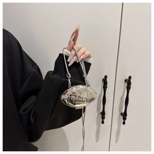 Détail du mini sac argenté en forme de coquille avec texture martelée et chaîne fine