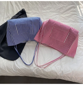 Flat lay of blue and red striped canvas tote bags with front pockets on a white background
