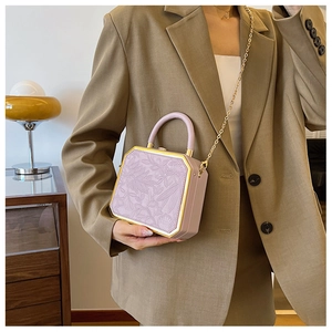 Detail view of light purple box bag with floral embossing and gold metal frame