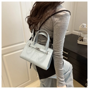 Close-up of light blue leather handbag with silver clasp and pebble texture finish