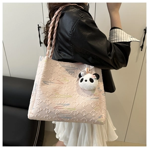 Pale pink tote bag with embossed pattern, braided straps, and panda plush charm detail