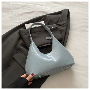 Close-up of light blue hobo bag with fashion embossing on grey suit fabric