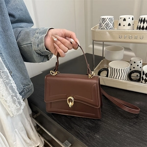 Minimalist deep brown faux leather crossbody bag with elegant golden circular twist lock