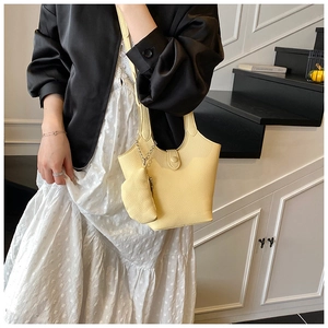 Detail of cream bucket bag with lychee texture and matching mini zipper pouch