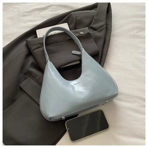Detail of light blue crescent leather shoulder bag with FASHION text and metal feet