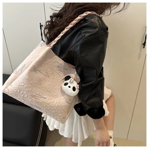 Pink quilted tote bag with colorful lightning embroidery and a panda plush charm detail
